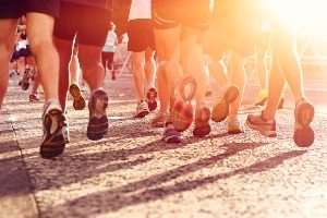  Close up of legs and feet of marathon runners in early morning light