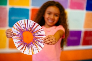 Young girl at Crayola Experience Orlando shows off her crayon artwork