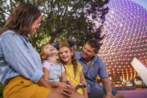 Orlando with a Toddler - A toddler sits outside Spaceship Earth at EPCOT with her family. 